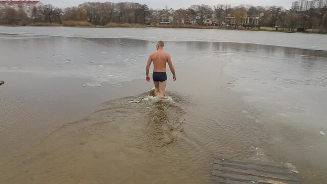  Bathing in icy water. Diving into icy water. Ice Swimming. Bathing in the ice-hole. Frozen river. 