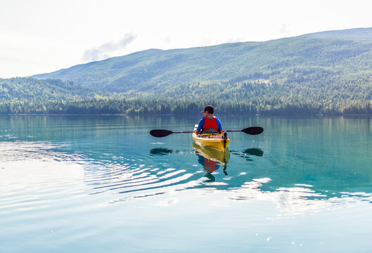 A teenage boy kayaking on White Lake, White Lake Provincial Park; British Columbia, Canada