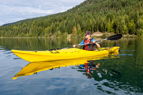 A teenage boy kayaking on White Lake, White Lake Provincial Park; British Columbia, Canada