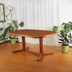 Table, mid-century modern dining room piece. Warm teak wood vintage furniture. Scene with white curtains, houseplants, and a dynamic retro- futurist lamp.