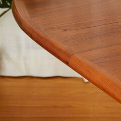 Table, mid-century modern dining room piece. Warm teak wood vintage furniture. Close up detail view with wood grain.