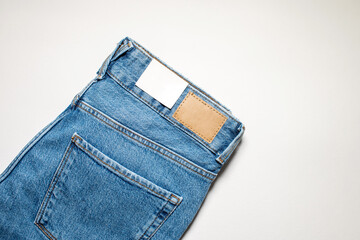 A pair of denim trousers with an empty leather label .