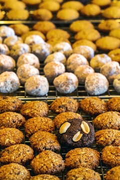 Close up of several different small round cookies all in rows on a cooling rack; Studio