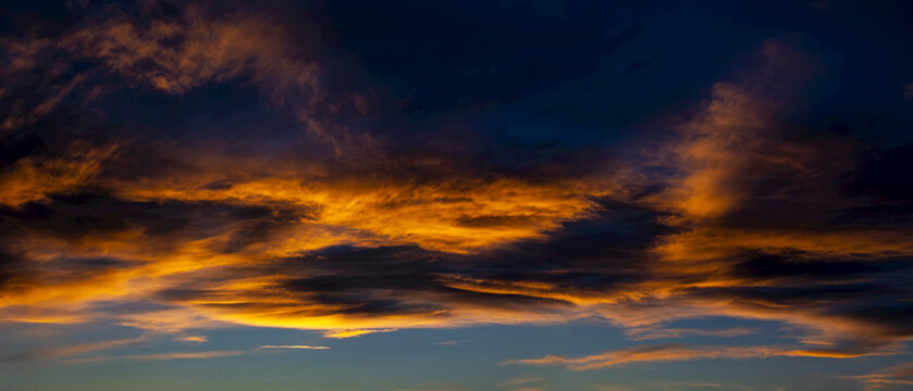 Colourful dramatic sky with glowing dark clouds; Calgary, Alberta, Canada