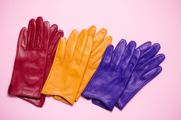 red, yellow and blue gloves on a pink background