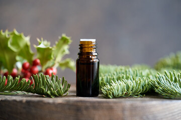 A dropper bottle of essential oil with fir branches