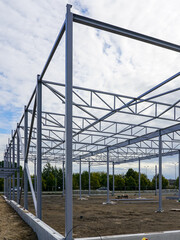 Assembled steel framework of new modern industrial building with foundation concrete panel border