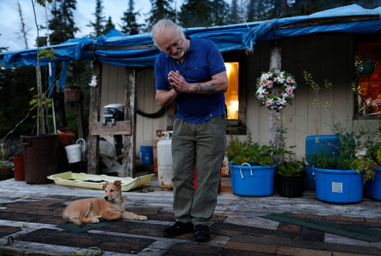 Swede, a float house owner, bows farewell to guests as they leave for the evening near Prince of Wales Island; Thorne Bay, Southeast Alaska, Alaska, United States of America