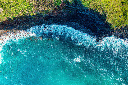 Aerial view from directly above of the rugged coastline and turquoise water with its frothy surf at Kahakuloa; Maui, Hawaii, United States of America