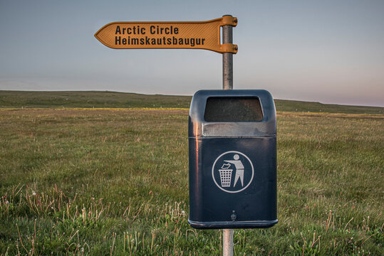 Trash can in Iceland's Husavik region with a directional sign pointing towards the Arctic Circle; Husavik, Iceland
