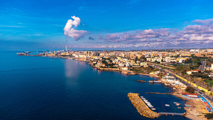 Civitavecchia coal power plant, air pollution visible on the crystalline sea. Top view with the drone on the sea