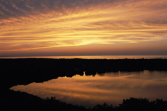 Sunset view of ocean and Scargo Lake looking north from Scargo Tower.; Dennis, Cape Cod, Massachusetts.