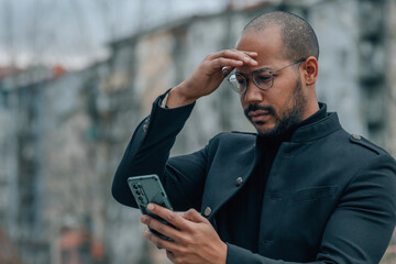 man in the street with mobile phone and expression of surprise