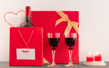 Fond d'écran pour la Saint-Valentin avec un paquet cadeau et du vin rouge. Composition romantique...