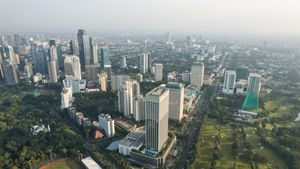 Fototapeta na wymiar Aerial view of office buildings in Jakarta central business district and noise cloud when sunset. 