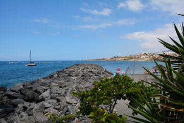 Hustle and bustle on the sea with many boats, rocks in the foreground