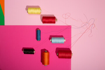 Coils of multicolored threads on a colored background