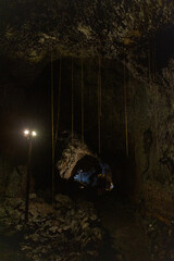 Exploring a volcanic cave in the Volcanic Caves Park at the foot of Villarrica volcano in Pucon,...