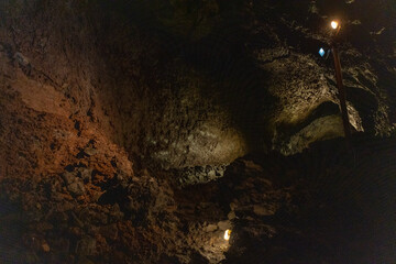 Exploring a volcanic cave in the Volcanic Caves Park at the foot of Villarrica volcano in Pucon, Chile 