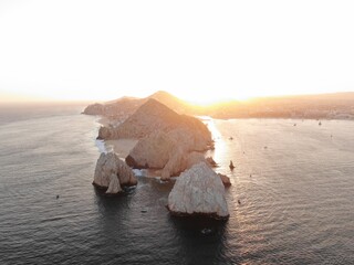 Aerial looking back at stone cliffs and bay of Cabo, Mexico