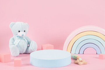 Baby kid toys background. Empty round podium platform stand and blue teddy bear, pastel color...