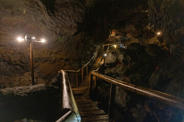 Exploring a volcanic cave in the Volcanic Caves Park at the foot of Villarrica volcano in Pucon,...
