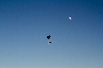 Powered Parachute flying against blue sky and moon