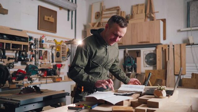 Male carpentry business owner closes successful deal over the phone and rejoices