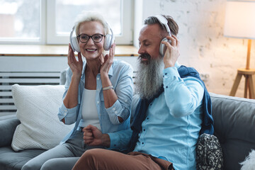 Happy loving senior couple having fun together, listening to the music in headphones. Mature man and woman using modern technologies, having active life. concept of pensioner leisure time