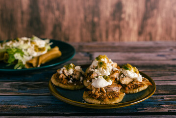Sopitos, typical mexican dish on wooden table. Sopes, Mexican snack.