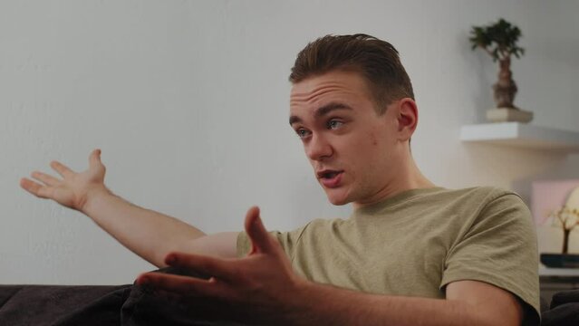 A Young Attractive Man Sits On Couch And Commands Football Match Film, He Is Very Dissatisfied With Result