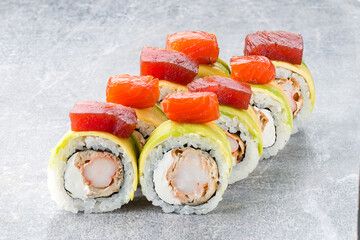 Set of sushi rolls with shrimp, tamago omelet, cream cheese, avocado, rice and nori topped tuna.
