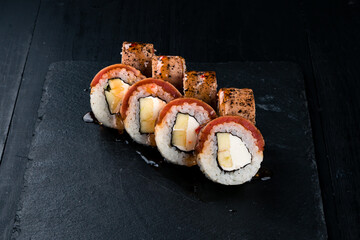 Set of sushi rolls with seared tuna, zucchini, cream cheese and sauce.