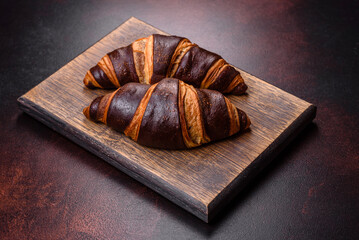Beautiful tasty fresh crispy croissant on a dark concrete background