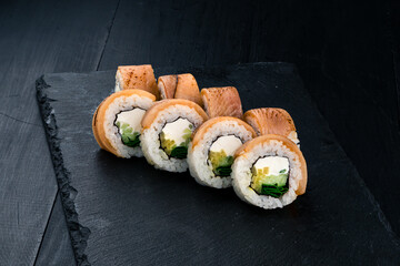 Set of maki sushi rolls with seared salmon, cream cheese, mango, cucumber and green onion.