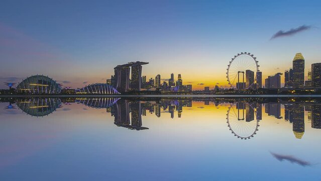 Beautiful Time lapse of Night to Day of silhouette singapore skyline by a river with reflection. Tilt up motion timelapse. Prores Full HD.
