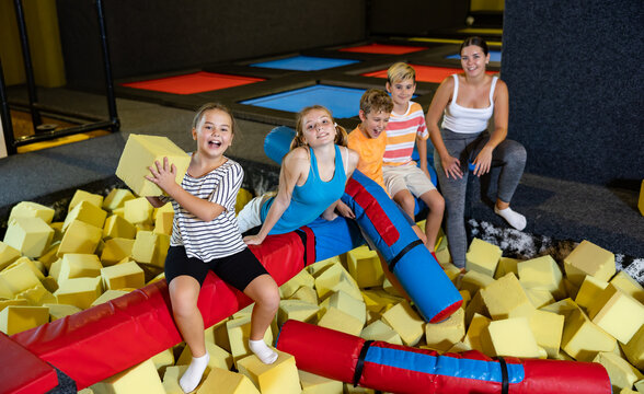 Group of excited active kids having fun while spending their weekend at indoor playground trampoline center