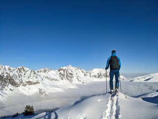 Fototapeta na wymiar person enjoys the fantastic view on the ski tour over the snowy mountains. Ski mountaineering in winter. Switzerland. High quality photo
