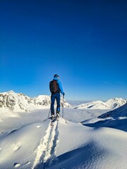 Fototapeta na wymiar Man enjoying the beautiful view on the ski tour. Beautiful winter landscape with lots of snow in the alps. Mountaineering on Silberen Glarus Uri in Switzerland. High quality photo