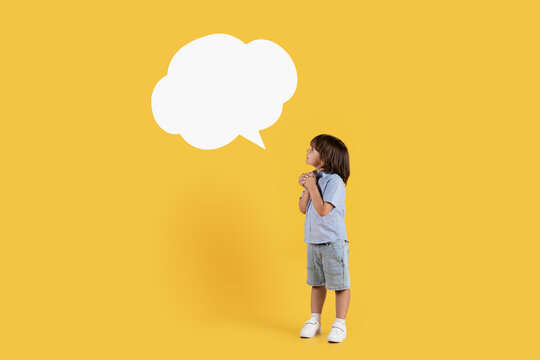 Kids dreams. Full length of cute little boy making wish, looking at white speech bubble with his dreamy toy, empty space - Powered by Adobe