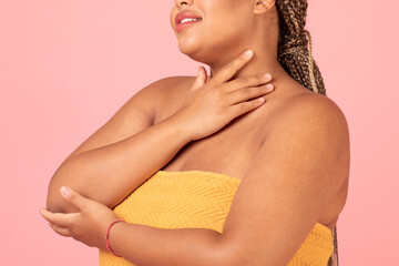 Self love and acceptance concept. Black plus size lady with perfect skin posing wrapped in towel over pink background