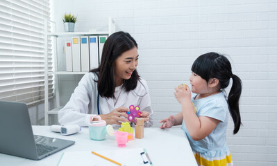 Asian doctor diagnosing playing with young patient, smiling happy getting tested concept, checking her healthy lifestyle, in hospital clinical office room, diagnosis for illness disease sickness