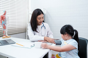 Asian doctor with patient young girl diagnosing health using blood pressure device, caring healthy lifestyle concept, in hospital office room, diagnosis illness disease sickness, healthcare expert