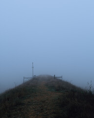 Foggy outdoor scene with hills and trails