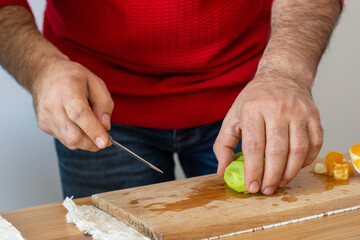 Man in red blouse cooking delicious fruit salad .