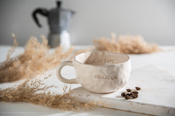 luxury hand made ceramic coffee cup with coffee beans and kettle
