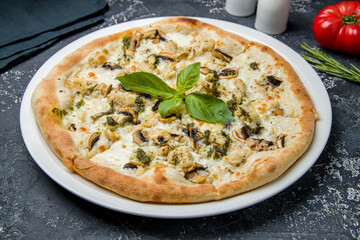 Pizza with chicken, cheese and mushrooms on dark table - 555260714