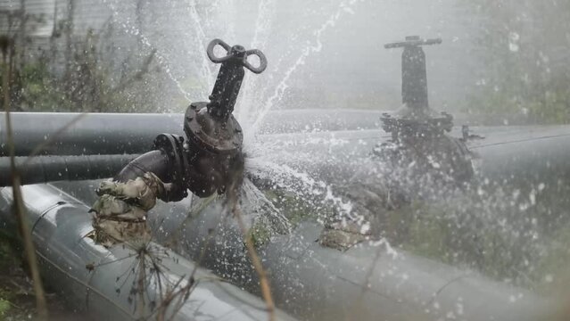 Valve on tube. Torn pipe valve. Boiling water pours from pipeline. 