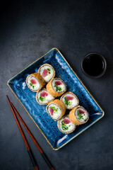 Fried sushi rolls with tuna, cream cheese, cucumber and lettuce.