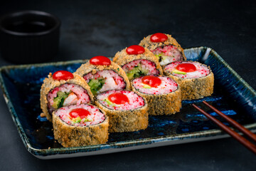 Fried sushi rolls with shrimp, cream cheese, avocado, flying fish caviar and sauce.